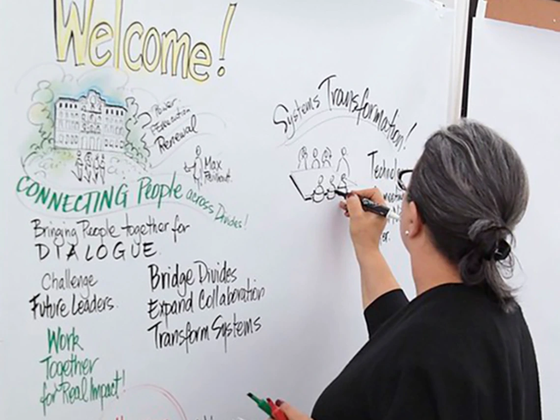 female teacher writing on a easel pad